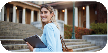 A female walking up the stairs while looking back and smiling.