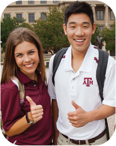 Two business students smiling at the camera and giving a thumbs-up.