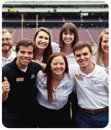 Business student council members smiling on Kyle field.