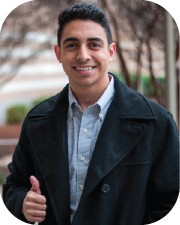 Male student smiling, giving a thumbs-up gesture.
