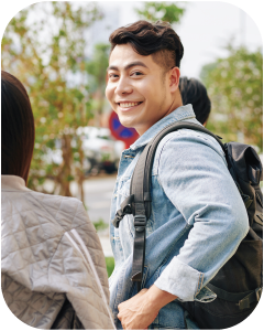Student smiling at the camera with a backpack on.