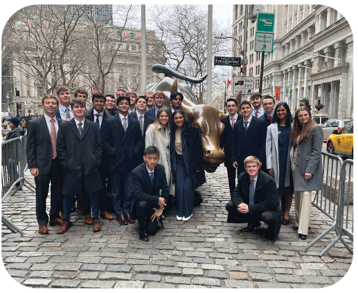 Group of students smiling in front of the Charging Bull in New York City.