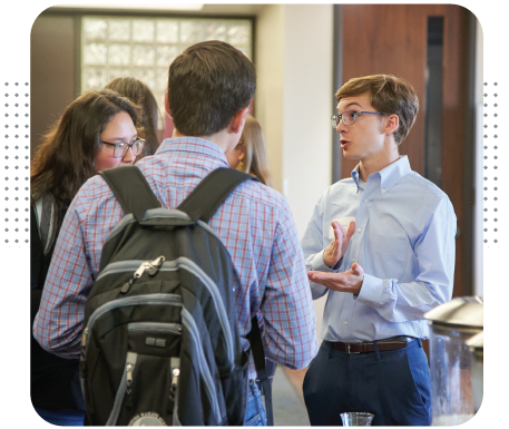 Business students talking to an advisor in the Wehner hallway.