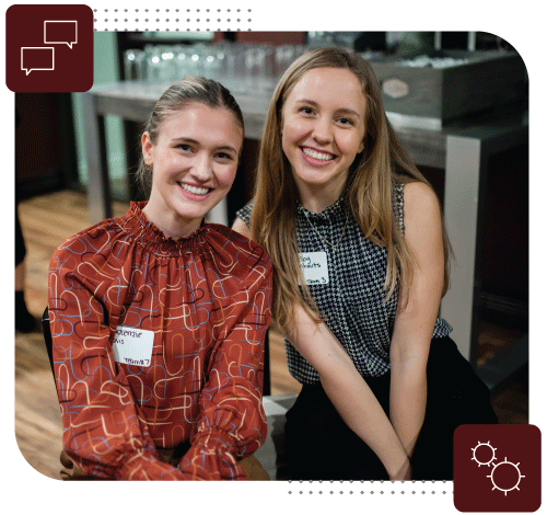 Two students smile together.