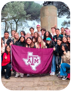 A group of students in the Regents' Ambassador Program posing for a photo with a Texas A&M flag.