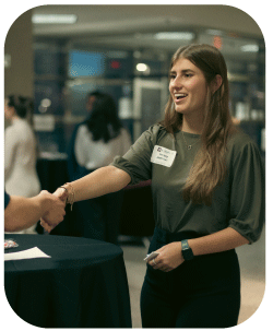 Student shaking hands at networking event.