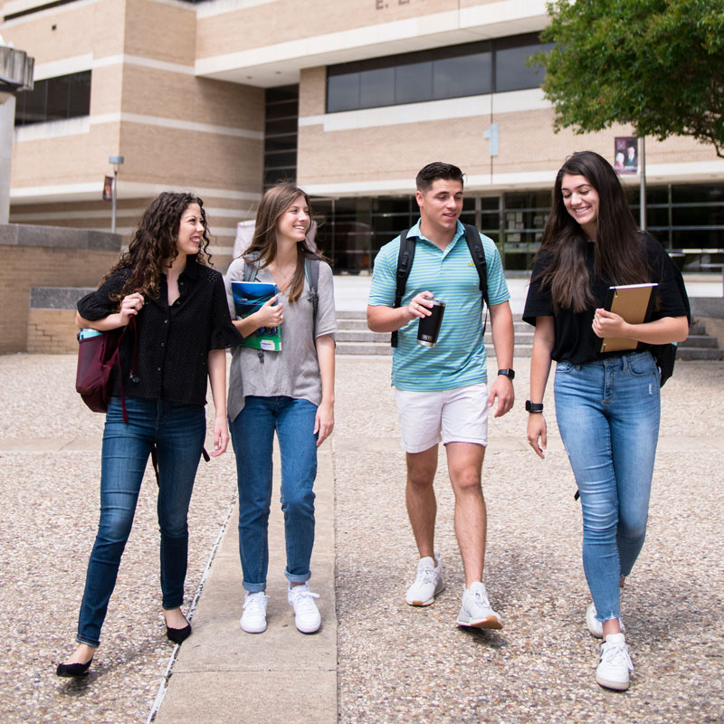 Business honor students walking and talking outside of Wehner