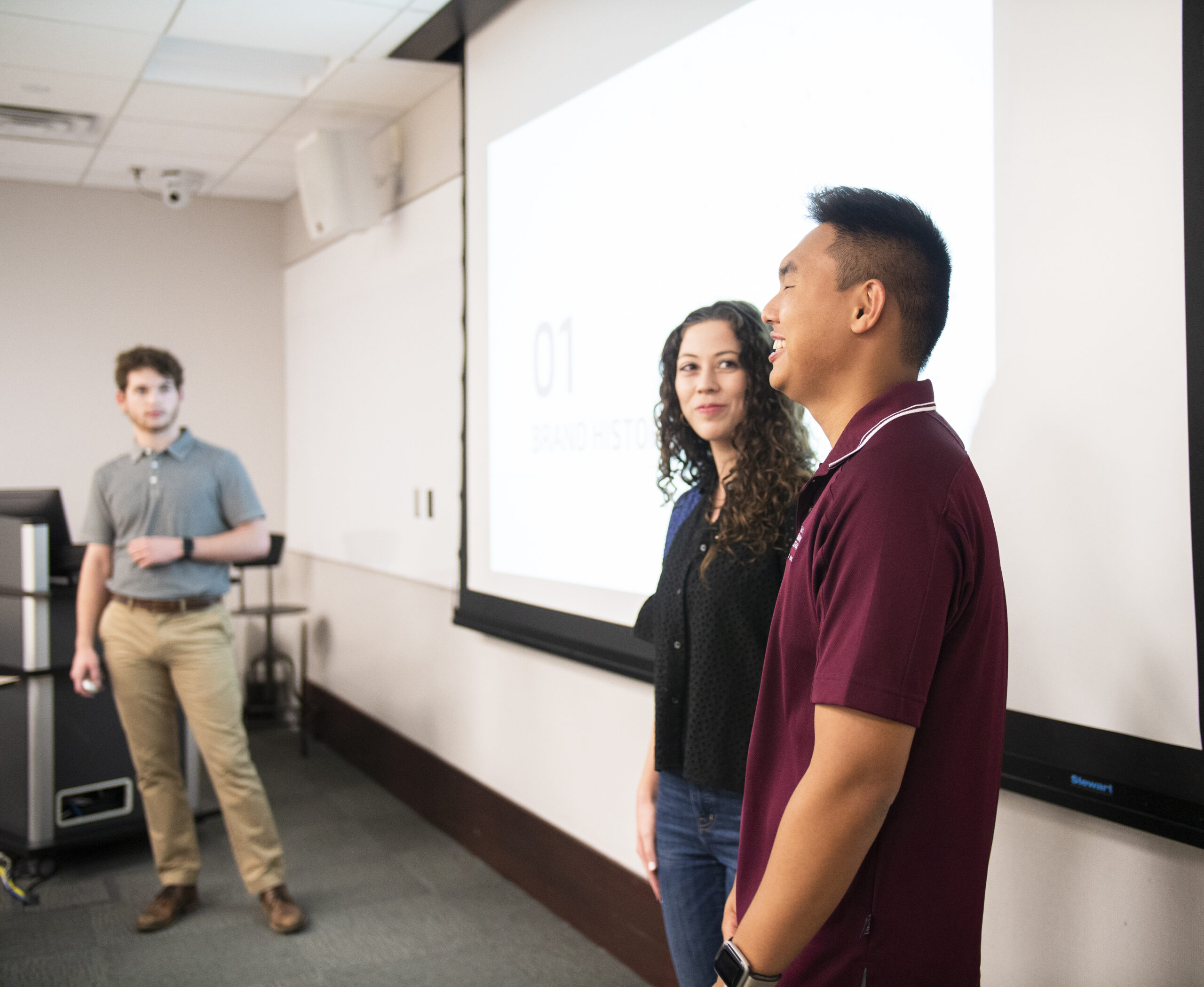 Three students making a presentation in a classroom