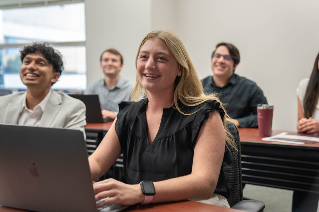 Several students smiling in a classroom