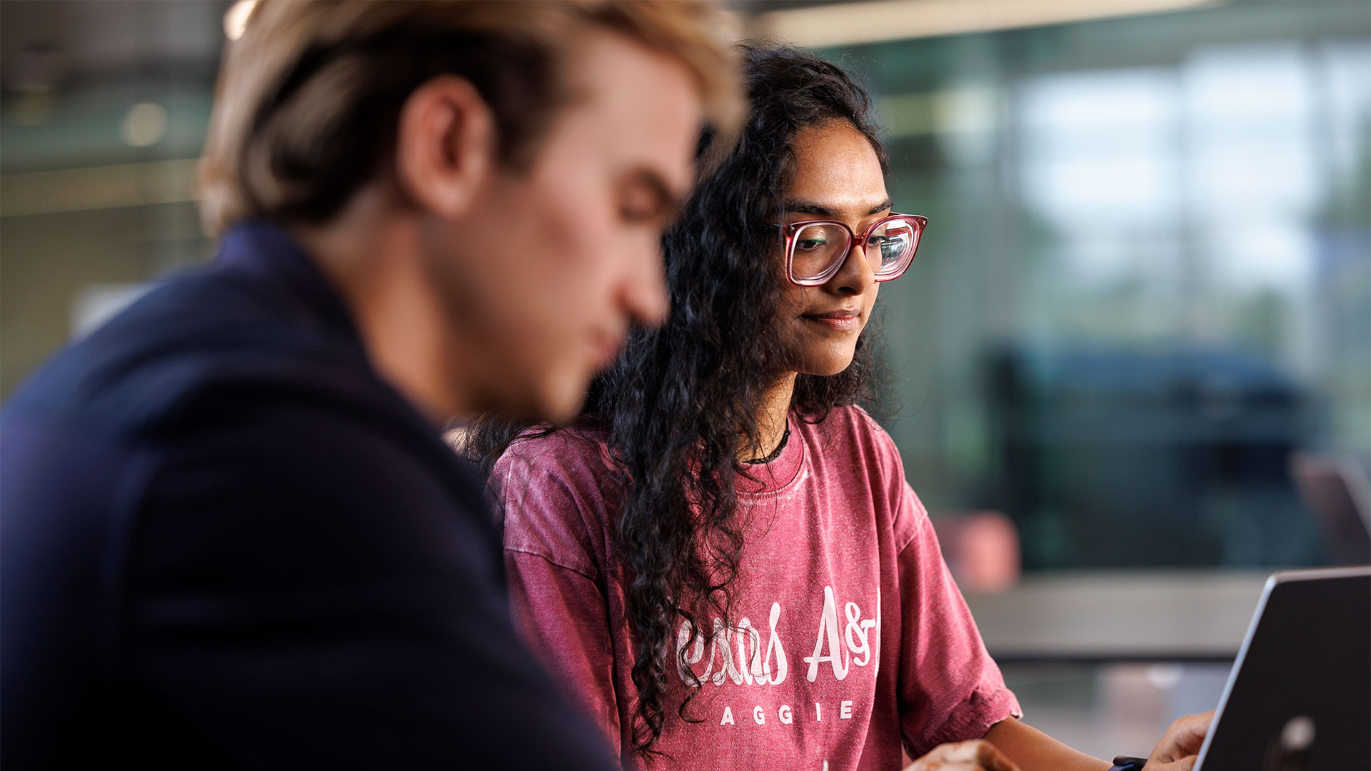 An Aggie works on a laptop in class