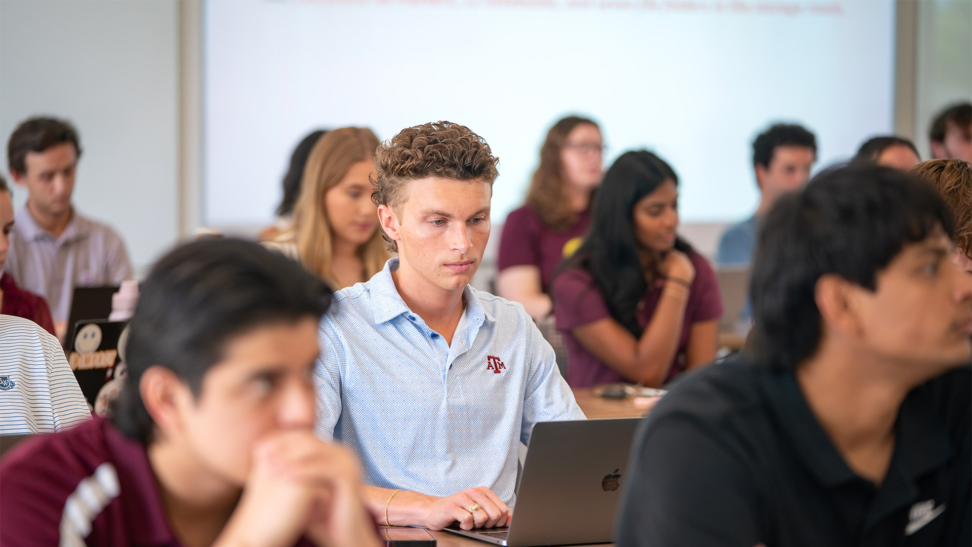 Supply Chain student focussed amongst a bunch of other students