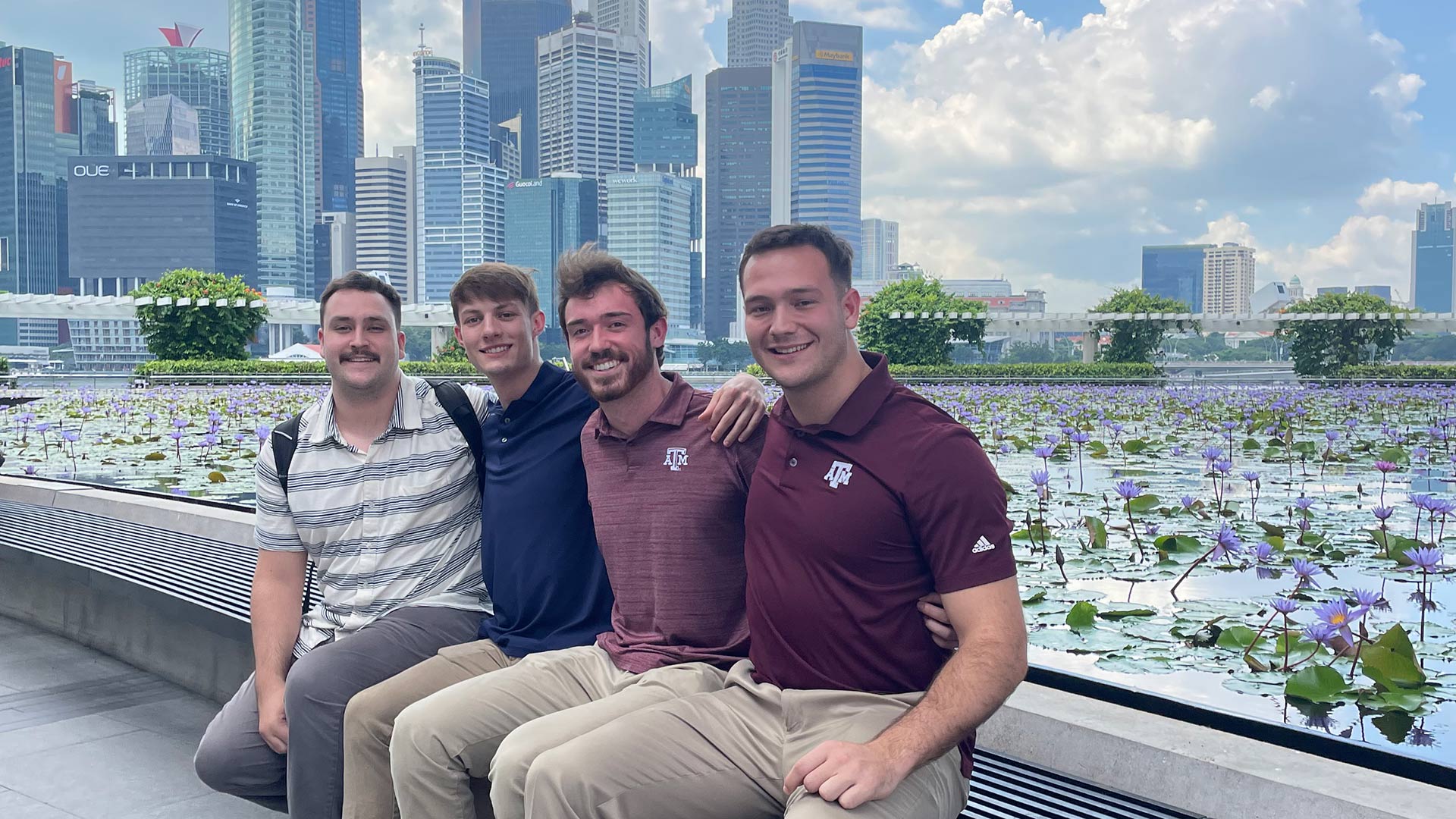 Students posing for a photo with tall skyscrapers in the background